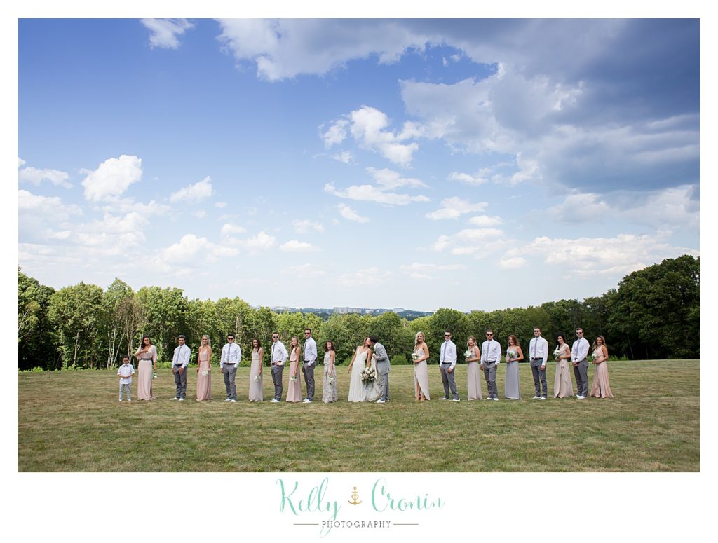 A wedding party stands in a field | Kelly Cronin Photography | Cape Cod Wedding Photographer