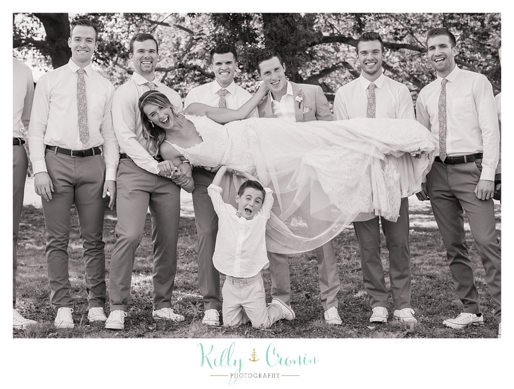 A groom's party holds the bride | Kelly Cronin Photography | Cape Cod Wedding Photographer
