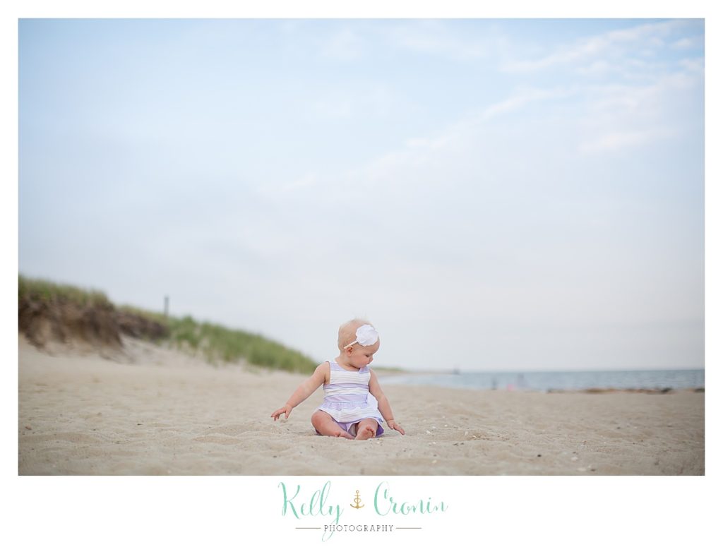 A baby plays on the shore | Kelly Cronin Photography | Cape Cod Family Photographer