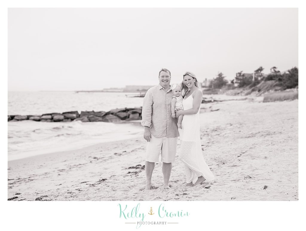 A family stands on the shore | Kelly Cronin Photography | Cape Cod Family Photographer