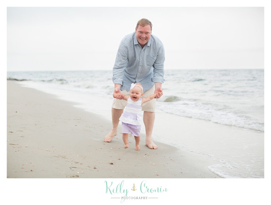 A father helps his baby walk | Kelly Cronin Photography | Cape Cod Family Photographer