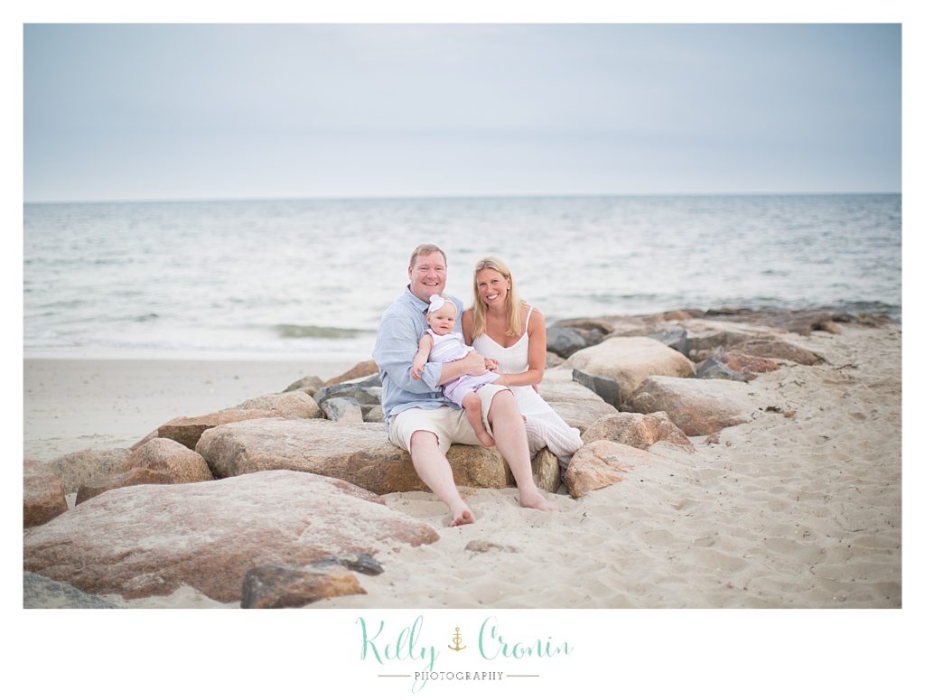 A family sits on some rocks on the beach | Kelly Cronin Photography | Cape Cod Family Photographer