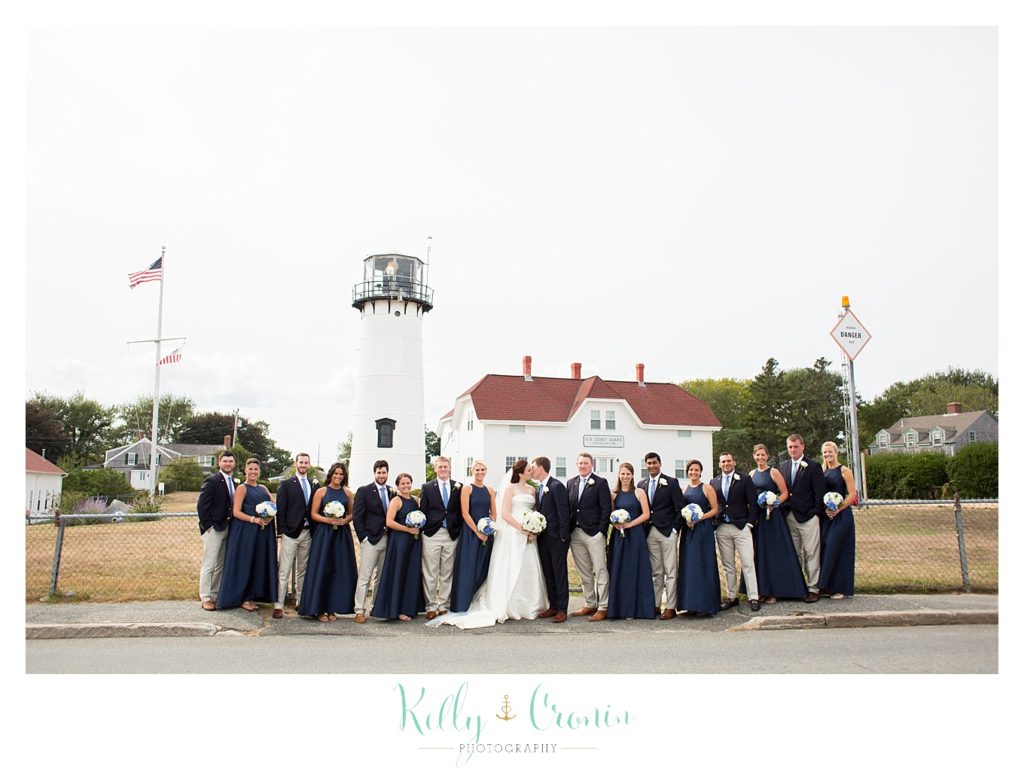 A wedding party stands in front of a lighthouse | Kelly Cronin Photography | Cape Cod Wedding Photographer