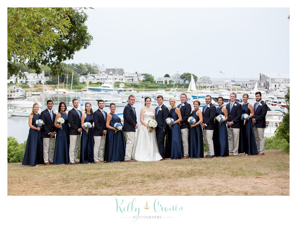 A bridal party stand in front of a marina | Kelly Cronin Photography | Cape Cod Wedding Photographer