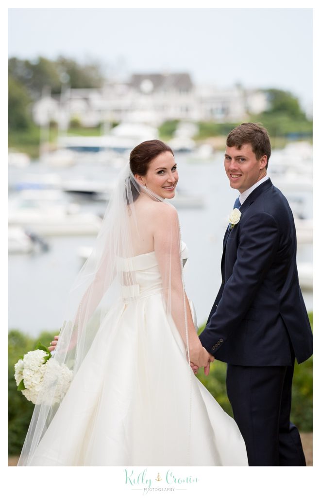 A groom and bride look over their shoulders | Kelly Cronin Photography | Cape Cod Wedding Photographer