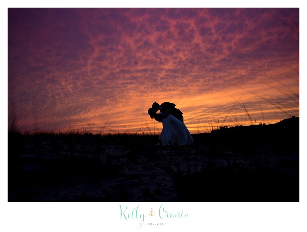 A groom kisses his bride at sunset | Kelly Cronin Photography | Cape Cod Wedding Photographer