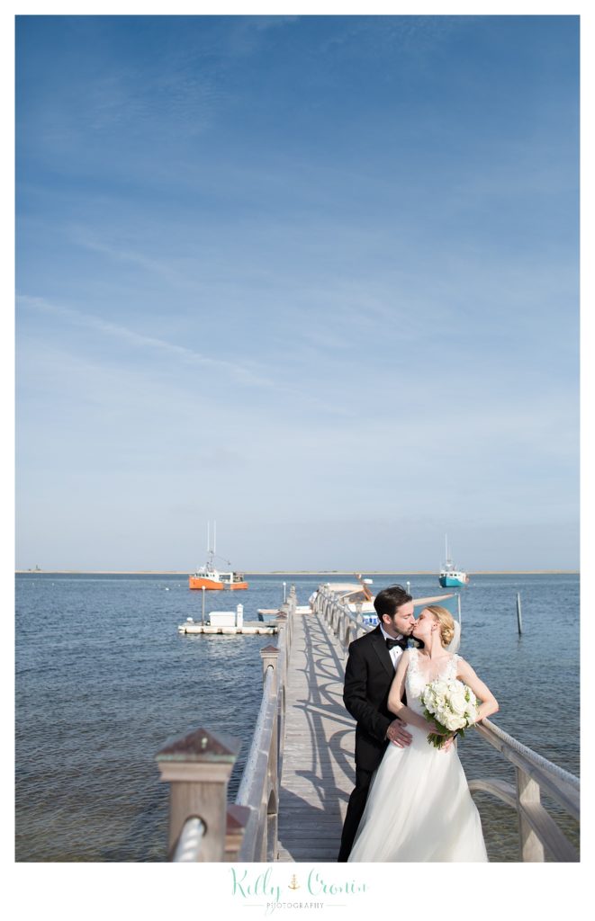 A bride and groom kiss on a pier | Kelly Cronin Photography | Cape Cod Wedding Photographer