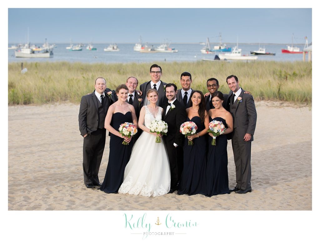 A wedding party stands on the beach | Kelly Cronin Photography | Cape Cod Wedding Photographer