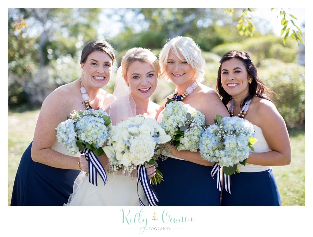 A bride poses| Kelly Cronin Photography | Cape Cod Wedding Photographer with her bridal party 