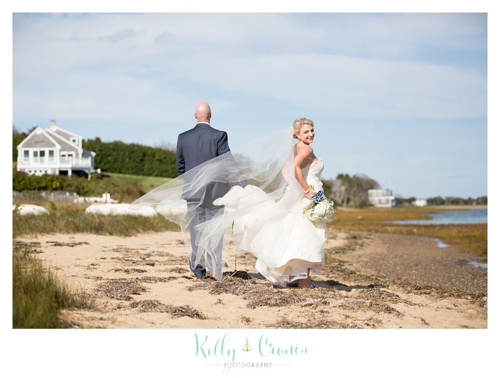 A bride turns around while walking | Kelly Cronin Photography | Cape Cod Wedding Photographer