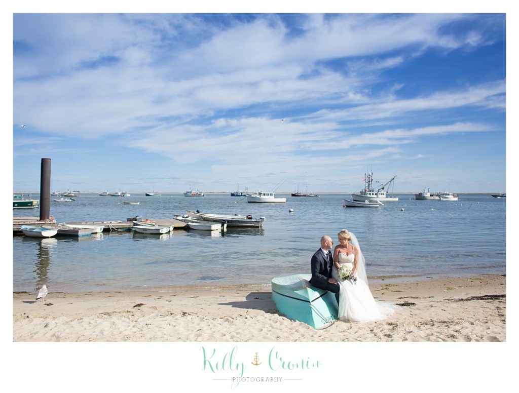 A newlywed couple sits on a small boat | Kelly Cronin Photography | Cape Cod Wedding Photographer