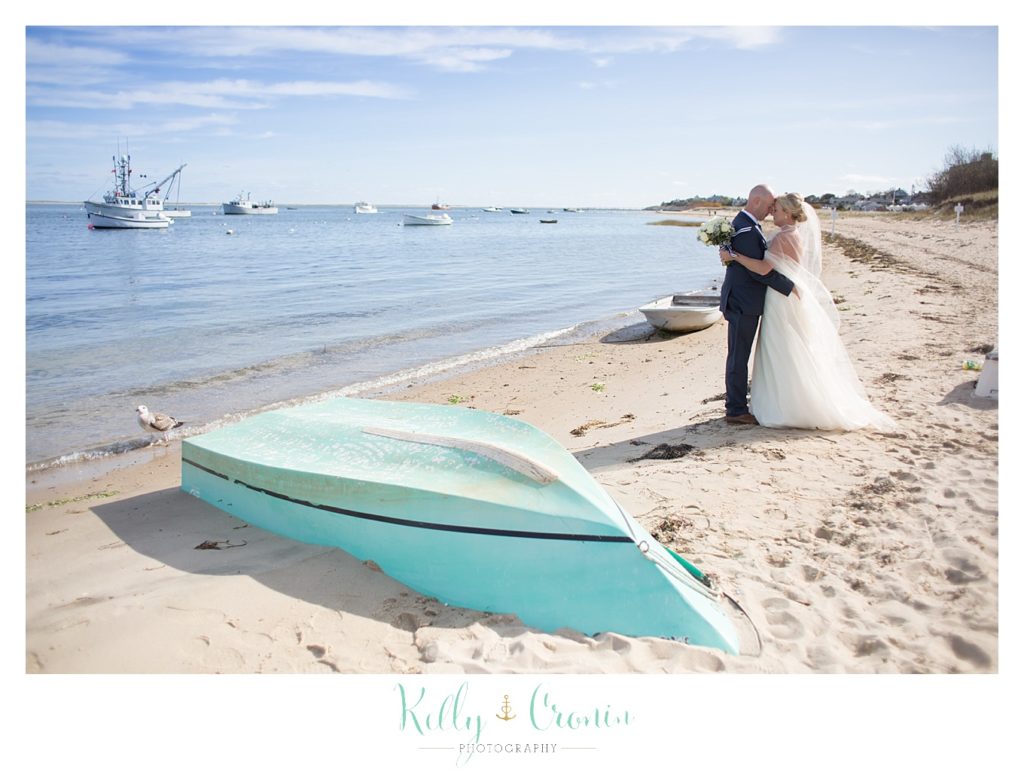 A couple kisses next to a boat | Kelly Cronin Photography | Cape Cod Wedding Photographer