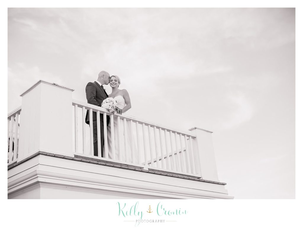 A couple stands on a balcony | Kelly Cronin Photography | Cape Cod Wedding Photographer