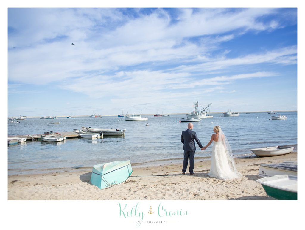 A newlywed couple holds hands | Kelly Cronin Photography | Cape Cod Wedding Photographer