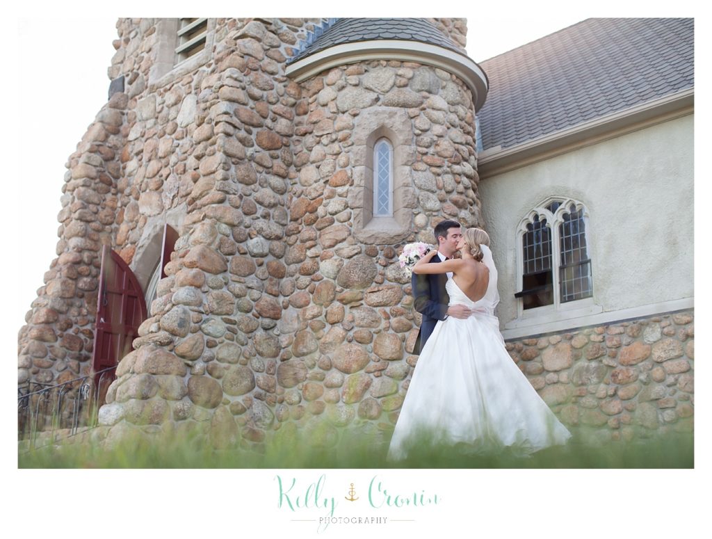 A couple kiss in front of their wedding venue  | Kelly Cronin Photography | Cape Cod Wedding Photographer