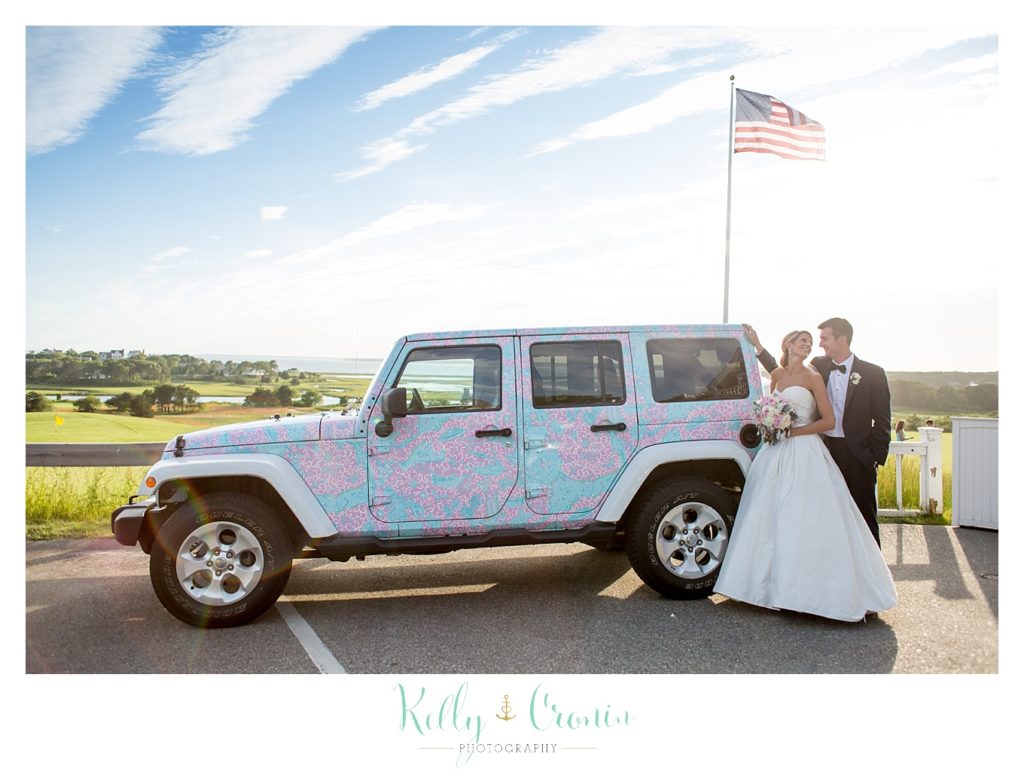A couple stands together in front of a colorful Jeep  | Kelly Cronin Photography | Cape Cod Wedding Photographer