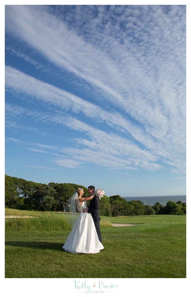 A couple stands under a blue sky  | Kelly Cronin Photography | Cape Cod Wedding Photographer