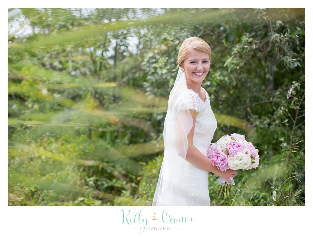 A bride looks over her shoulder  | Kelly Cronin Photography | Cape Cod Wedding Photographer