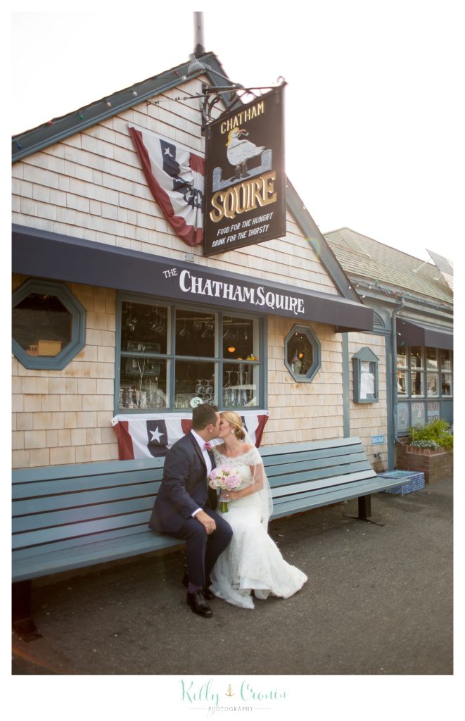 A bride and groom kiss on a bench  | Kelly Cronin Photography | Cape Cod Wedding Photographer