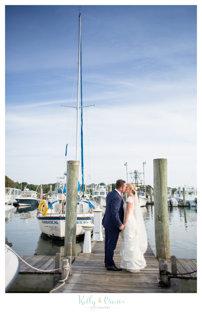 A couple kiss in front of a boat  | Kelly Cronin Photography | Cape Cod Wedding Photographer