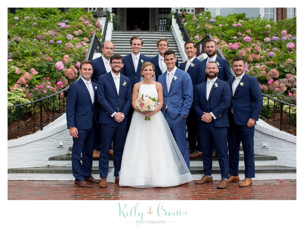 A bride stands with the groom's party | Kelly Cronin Photography | Cape Cod Wedding Photographer