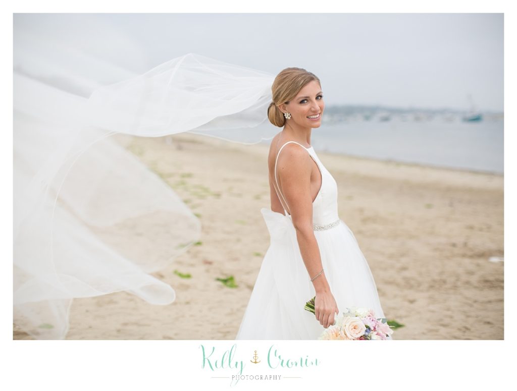 A bride stands on the beach | Kelly Cronin Photography | Cape Cod Wedding Photographer