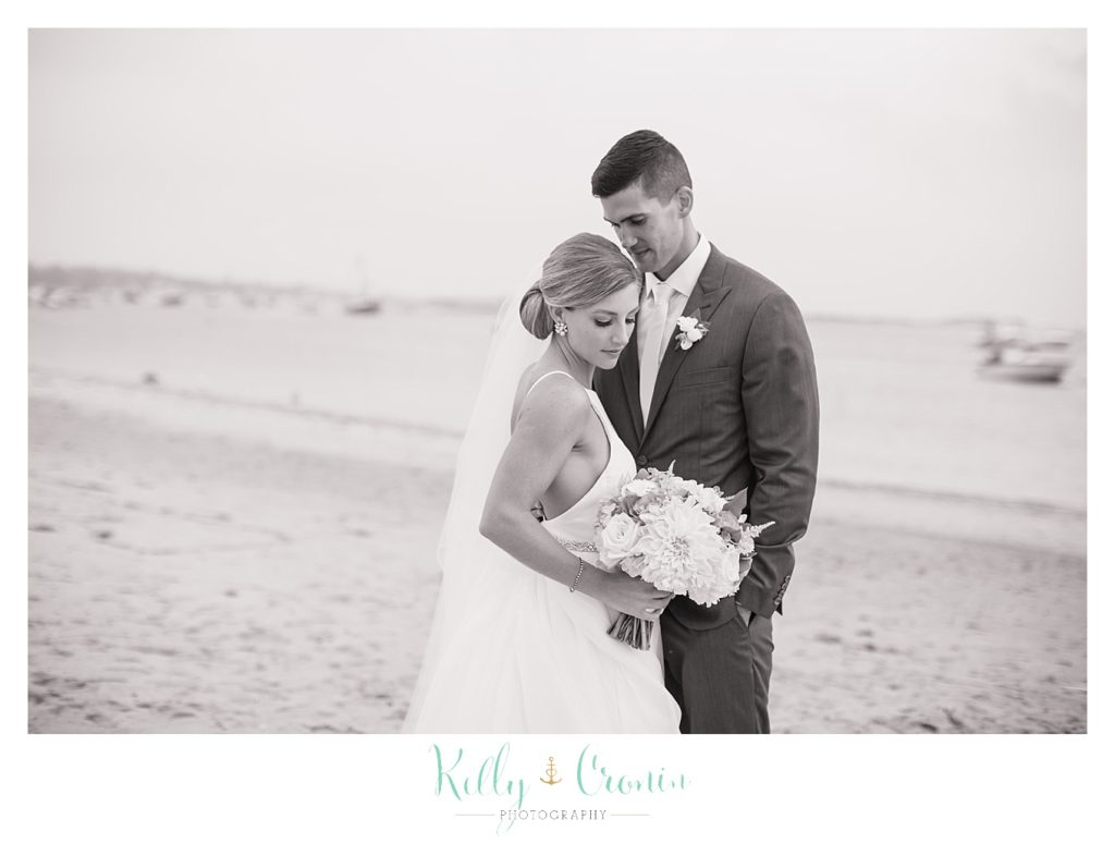A man holds his bride on the beach | Kelly Cronin Photography | Cape Cod Wedding Photographer