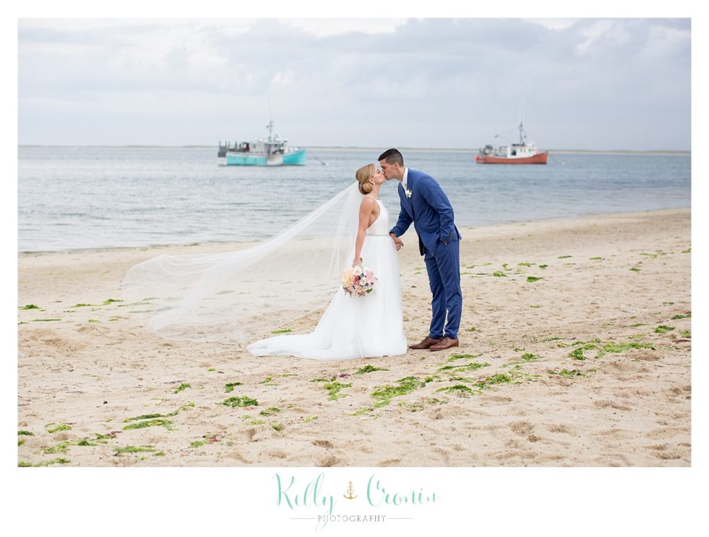 A groom kisses his bride on the beach | Kelly Cronin Photography | Cape Cod Wedding Photographer