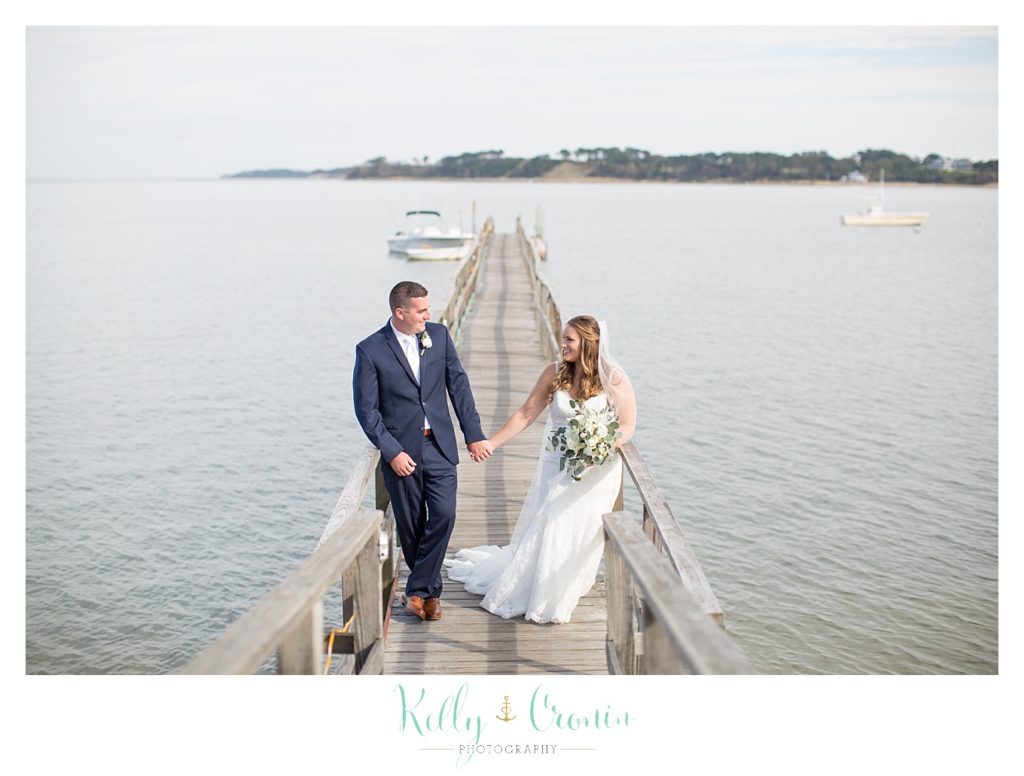 A couple walk along a pier | Kelly Cronin Photography | Cape Cod Wedding Photographer