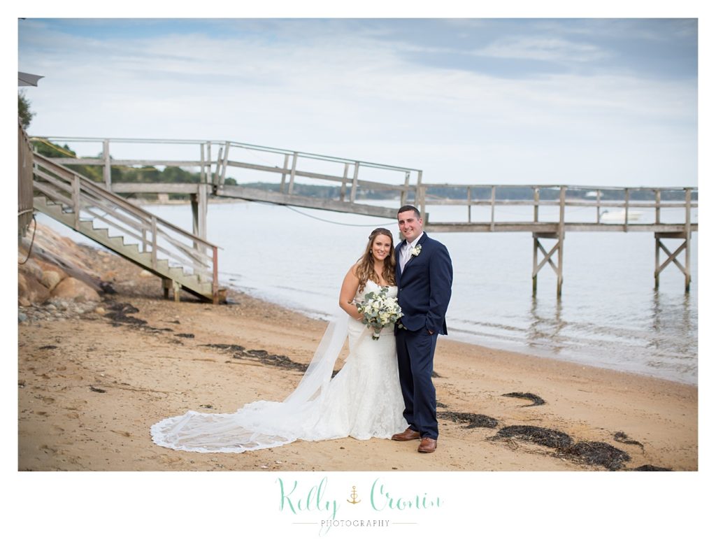A bride and groom stand on the beach | Kelly Cronin Photography | Cape Cod Wedding Photographer