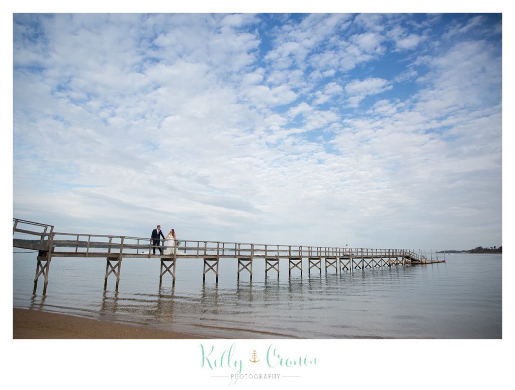A bride and groom walk out onto a pier | Kelly Cronin Photography | Cape Cod Wedding Photographer