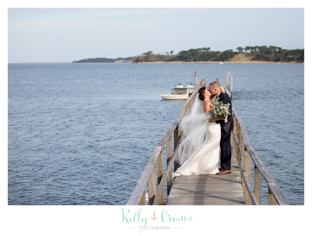 A newlywed couple kisses on a pier | Kelly Cronin Photography | Cape Cod Wedding Photographer