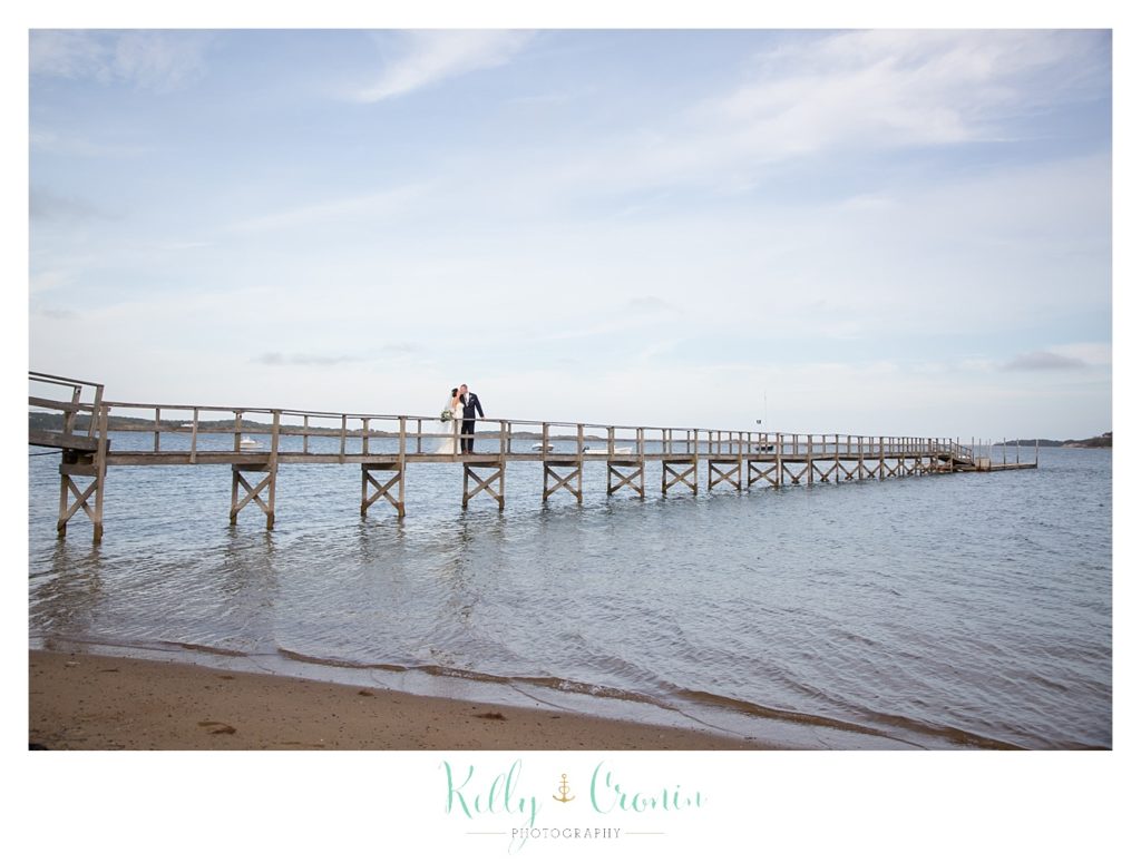 A bride and groom are on a pier | Kelly Cronin Photography | Cape Cod Wedding Photographer