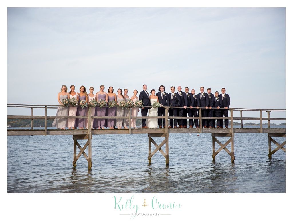 A wedding party stands on a pier | Kelly Cronin Photography | Cape Cod Wedding Photographer