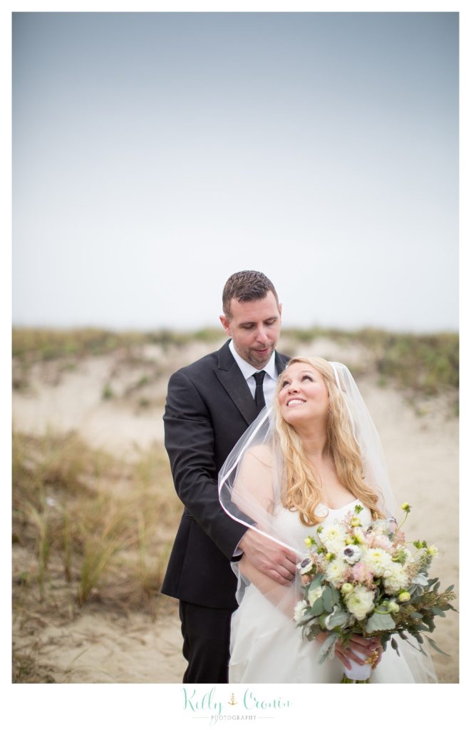 A man holds his new wife close  | Kelly Cronin Photography | Cape Cod Wedding Photographer