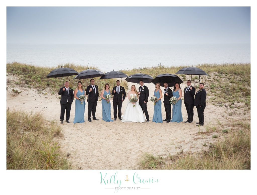 A wedding party holds umbrellas  | Kelly Cronin Photography | Cape Cod Wedding Photographer