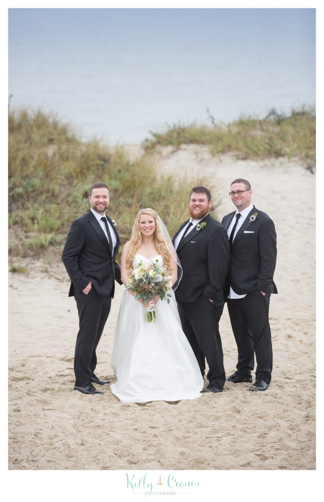 A bride stands with groomsmen  | Kelly Cronin Photography | Cape Cod Wedding Photographer