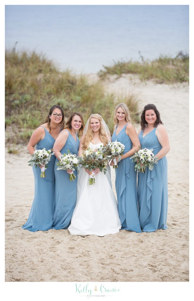 A bride and her friends stand on the beach  | Kelly Cronin Photography | Cape Cod Wedding Photographer