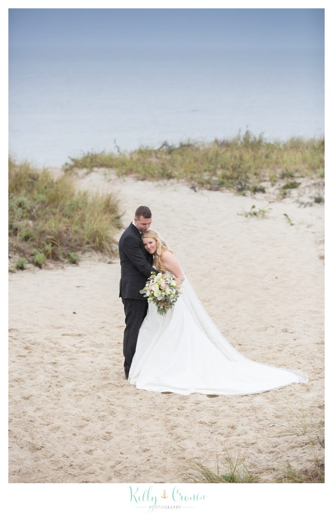 A wife rests her head on her groom  | Kelly Cronin Photography | Cape Cod Wedding Photographer