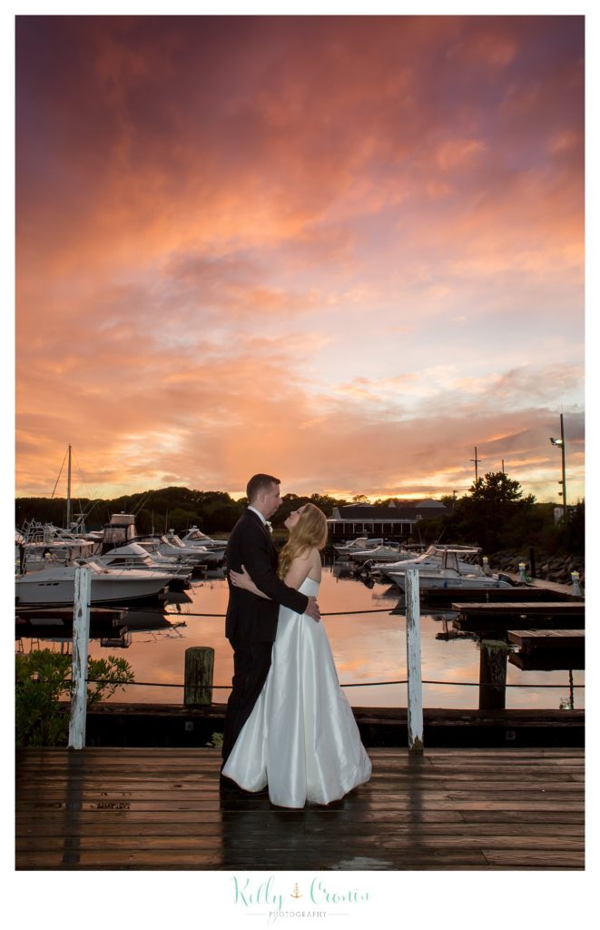 A couple hug under a sunset  | Kelly Cronin Photography | Cape Cod Wedding Photographer