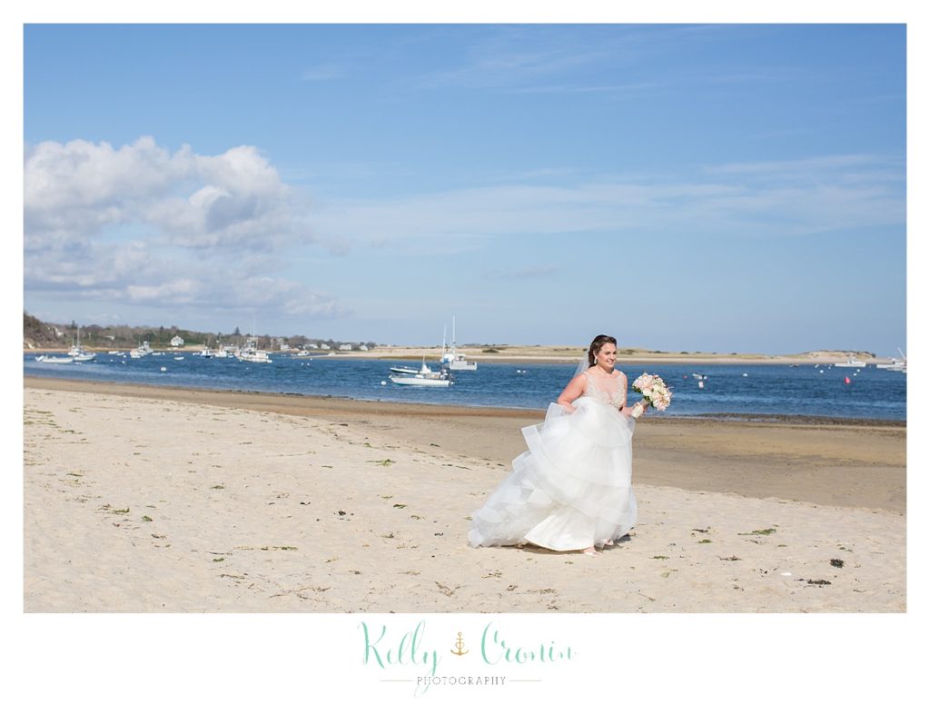 A bride walks along the shore | Kelly Cronin Photography | Cape Cod Wedding Photographer