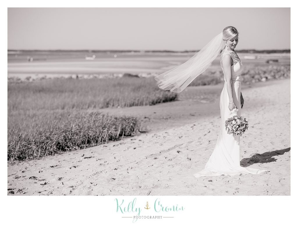 A bride stands on the shore | Kelly Cronin Photography | Ocean Edge Resort and Golf Club