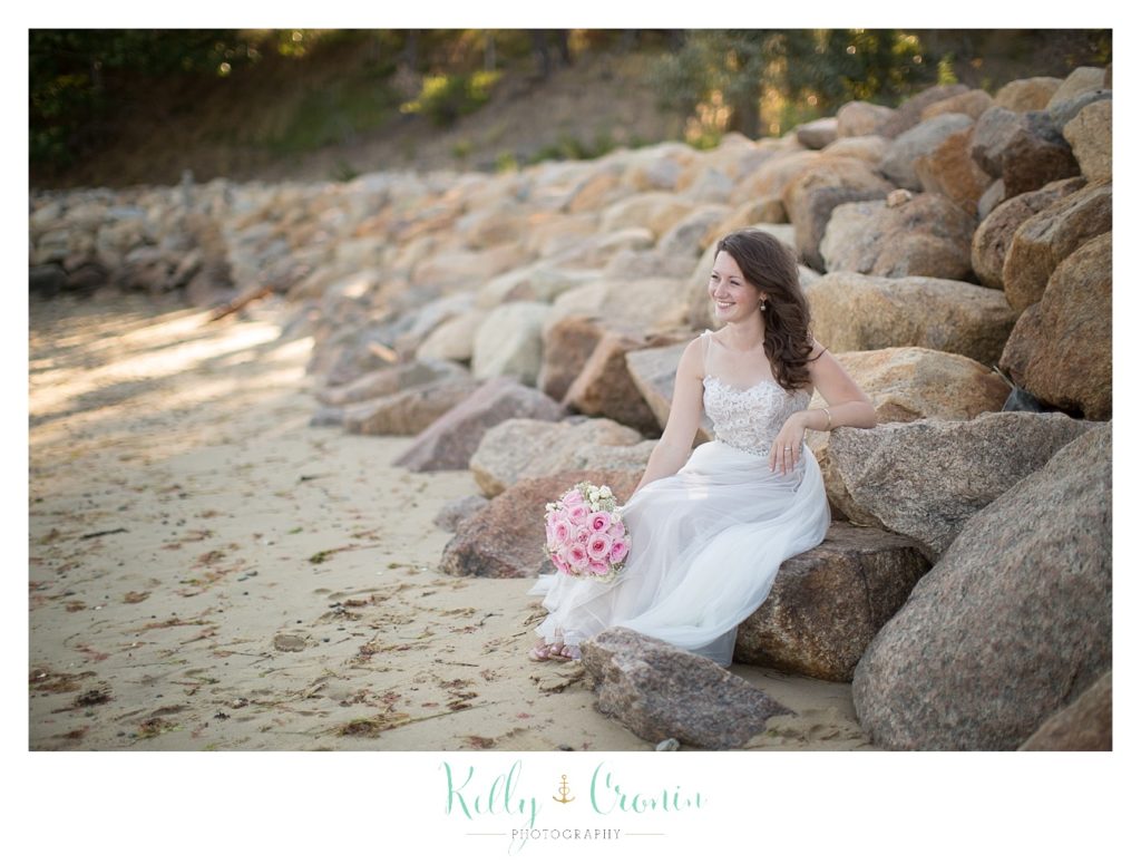 A bride sits on some rocks | Wedding Photographer in Cape Cod | Kelly Cronin Photography