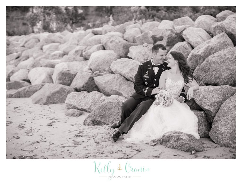 A newlywed couple sit on some rocks | Wedding Photographer in Cape Cod | Kelly Cronin Photography