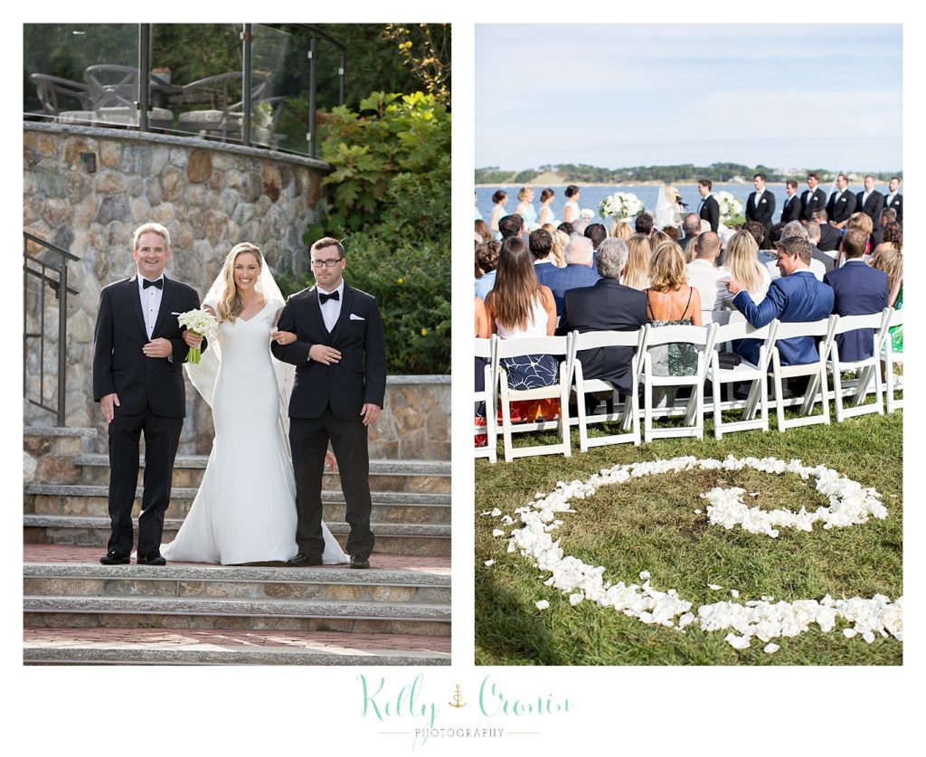 Two men walk the bride down the aisle towards her Romance in Cape Cod. | Captured by Kelly Cronin Photography