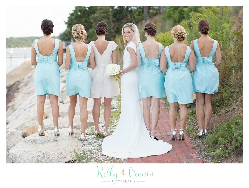 A bridal party shows off their dresses in celebration of the bride's Romance in Cape Cod. | Captured by Kelly Cronin Photography
