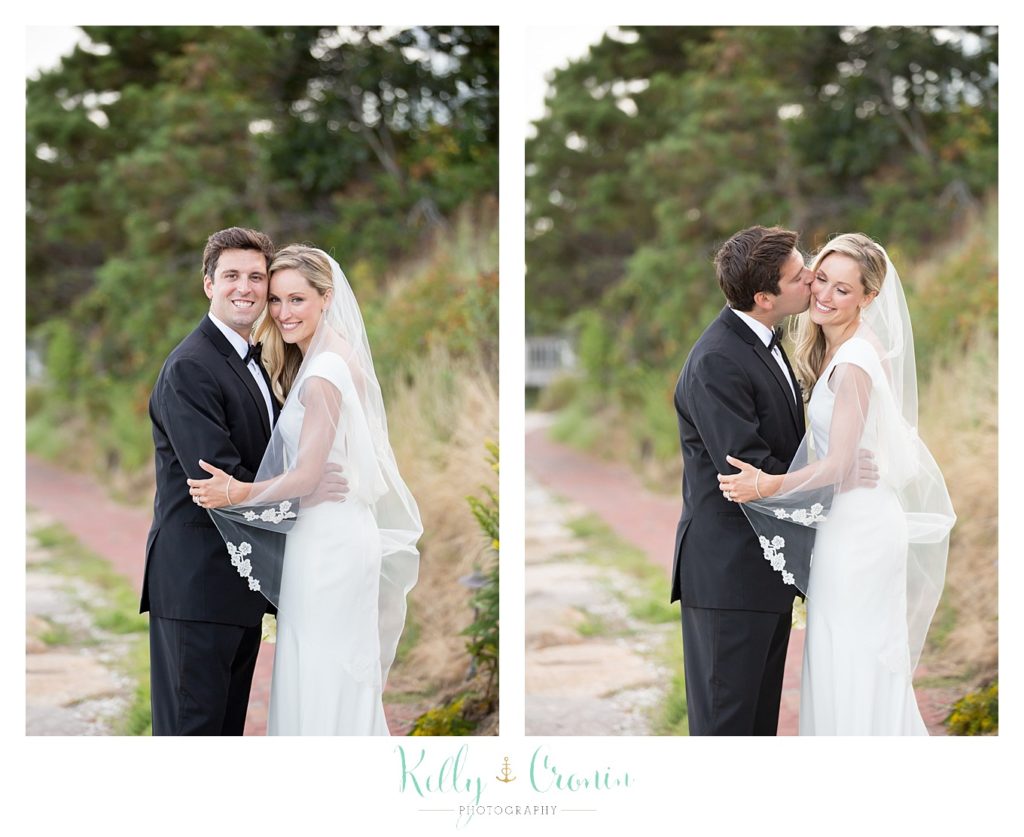 A man kisses his bride, they're celebrating their Romance in Cape Cod. | Captured by Kelly Cronin Photography