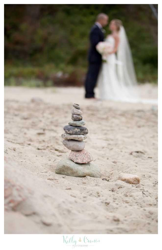 Stones are piled in front of a bride and groom, wedding held at the White Cliffs Country club and captured by Kelly Cronin Photography