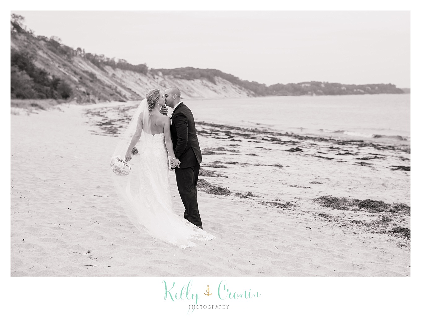 A newlywed couple stroll along the shore together, wedding held at the White Cliffs Country club and captured by Kelly Cronin Photography