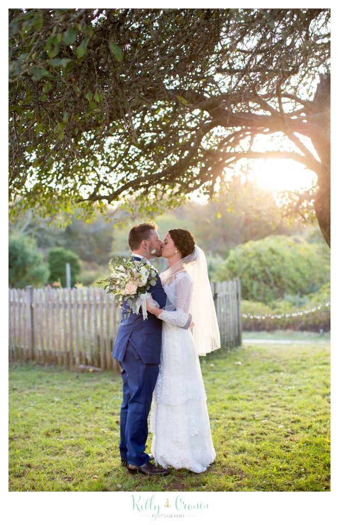 A bride kisses her groom, this was a Mooncussers Tavern Reception, captured by Kelly Cronin Photography
